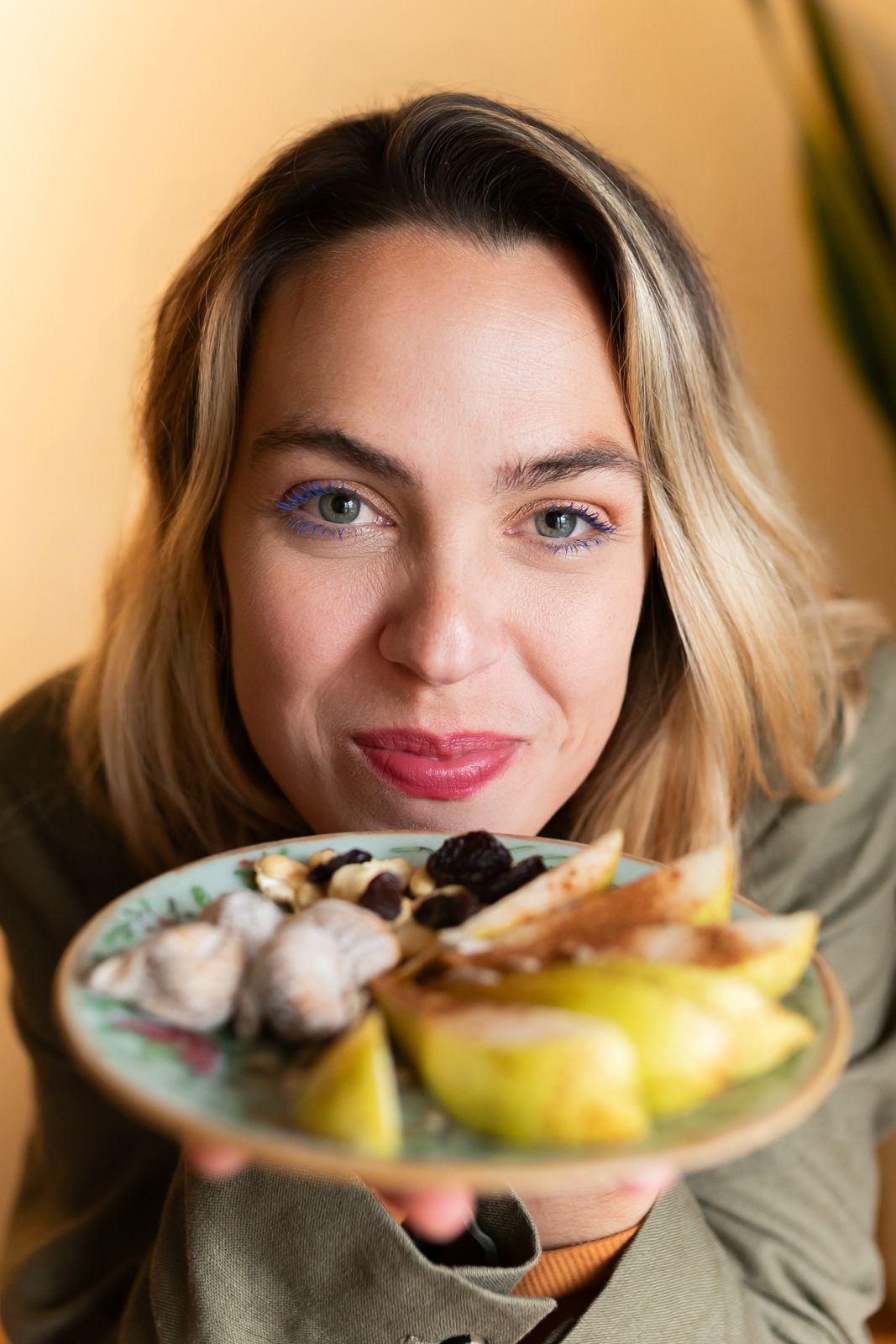 Natasha Melman segurando um prato com frutas e oleaginosas